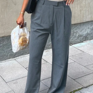Grå kostymbyxor från Djerf Avenue - Grå kostymbyxor från Djerf Avenue i storlek M. Köpta på vinted men kom aldrig till användning, upplevde att de var lite för baggy/wide för min smak, och flyttrensar nu så det är därför säljer dem💗  Strl M, långa versionen (tall).  Nypris 1500kr.