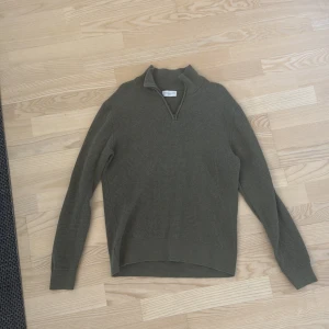 Stickad tröja med half zip - Snygg olivgrön stickad tröja från These Glory Days i storlek medium. Tröjan har en ribbad krage och half zip framtill, perfekt för lager-på-lager under höst och vinter. Använd max 5 gånger. Passar på S o M