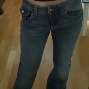 Blå jeans  - Säljer ett par klassiska blå jeans med hög midja och raka ben. Jeansen har fem fickor, knapp- och dragkedjestängning samt snygga sömmar. Perfekta för en chill och stilren look. Aldrig använda för fel storlek🤗