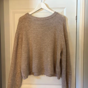 Beige stickad tröja från 157 - Mysig beige stickad tröja från 157 i storlek M. Tröjan har en rund halsringning och långa ärmar.
