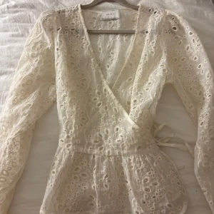Omlotts blus - Superfin vit omlottblus från Neo Noir med broderade blommor och spetsdetaljer i storlek 34. Knappt använd. Nypris 599 kr