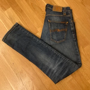 Nudie Jeans Grim Tim - Säljer ett par snygga Nudie Jeans modell Grim Tim och färg organic twisted blue. Slim fit med kamppgylf. Riktigt schyssta jeans som tyvärr är för små i midjan för mig. Tveka inte! 