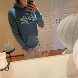 Superdry hoodie!! - Säljer en otroligt snygg blå hoodie från Superdry. Skicket på tröjan är bra och passformen är slim fit! Storleken är S/M. Färgen är en otroligt snygg blå färg som passar till det mesta! Vid fler frågor är det bara att höra av er!
