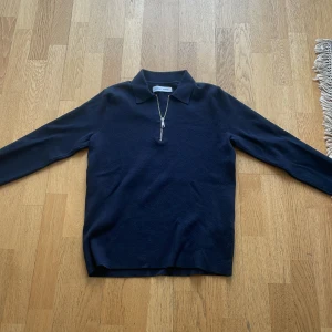 Mörkblå långärmad pikétröja med dragkedja från Samsøe Samsøe - Snygg mörkblå långärmad pikétröja från Samsøe Samsøe med klassisk krage och dragkedja framtill. Perfekt för en stilren och avslappnad look. Mjukt material och enkel att matcha.