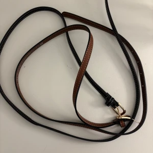 Svart och brunt bälte med guldfärgat spänne - Säljer två super fina bälten, antingen ihop eller separat. Enklast ihop. Längden är 110cm passar mig som har 36/38 i stl i jeans om det är intressant 🌸 1 för 59kr och två för 100kr Använda 1 gång. Bältet har en klassisk design och passar perfekt till jeans eller klänning. Enkelt att justera längden.