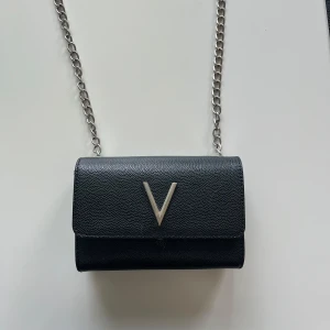 Svart axelväska med silverkedja och V-detalj - Valentino väska divina, dock har stycket där fram gått sönder, därav billigt pris 