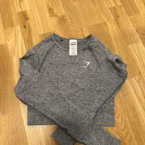 Grå croppad långärmad träningströja från Gymshark - Träningströja ifrån gymshark, storlek S🦋