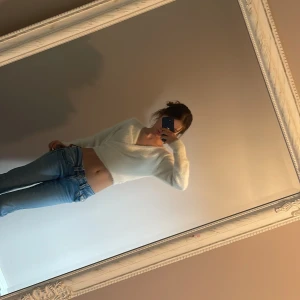 Vit fluffig omlottkofta - Säljer en supermjuk och fluffig vit omlottkofta med knytband i midjan. Koftan har lång ärm och är croppad i modellen, perfekt att styla med jeans eller kjol. Materialet känns stickat och mysigt. Jag köpte koftan på H&M två år sedan och har inte använt den så mycket. 