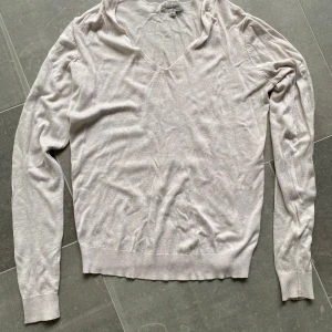 Ljusbeige v-ringad tröja från Ullared  - Säljer en stilren ljusbeige v-ringad tröja från Ullared. Tröjan har långa ärmar och är tillverkad i ett tunt, mjukt material som passar perfekt för lager-på-lager. Klassisk och enkel design. 