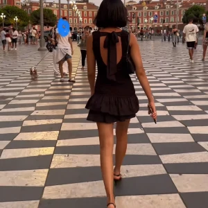 Svart volangklänning med rosett i ryggen från Zara  - Supersöt svart kortklänning med volangkjol och v-ringning. Klänningen har en öppen rygg med stor rosett. Den är stretchig och helt oanvänd. Nypris 499. Finns inte i appen att köpa men artikel numret är 0881/366 