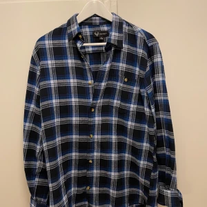 Flanellskjorta  - Säljer en klassisk flanellskjorta från Jägarliv i storlek S. Skjortan har långa ärmar, knappar framtill och en bröstficka. Perfekt för dig som gillar en avslappnad och tidlös stil.
