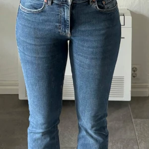 Blå bootcut jeans från Gina - Säljer ett par klassiska blå jeans med bootcut passform och normal midja. Jeansen har fem fickor, dragkedja och knapp framtill. Jag ör 160cm lång.