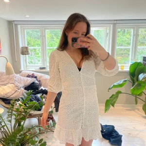 Vit spetsklänning med volang - Söt vit klänning med spetsdetaljer och volang nertill. Klänningen har v-ringning och trekvartsärm, perfekt för sommaren!!!