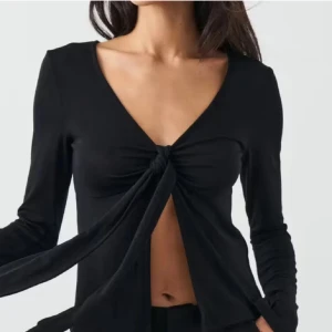 Svart långärmad topp med knyt framtill - Trendig svart långärmad topp med djup v-ringning och knyt framtill. Aldrig advänd. Pris kan diskuteras☺️💕