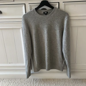 Grå kashmirtröja från Uniqlo - Säljer en stilren grå kashmirtröja från Uniqlo. Tröjan har en klassisk rund hals och långa ärmar. Den är tillverkad i 100% kashmir vilket gör den extra mjuk och bekväm. Priset kan diskuteras.