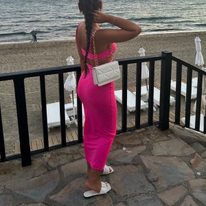 Rosa  klänning - Snygg rosa klänning med tight passform. Perfekt för sommarens varma dagar vid stranden. Klänningen har en stilren design som framhäver figuren.