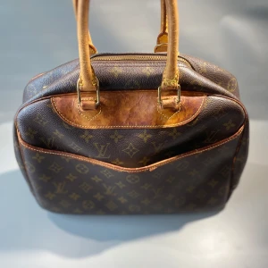 Louis Vuitton Handväska  - Hej! Säljer nu denna Louis Vuitton Monogram Deauville R605 handväska. Serienummer M47270. Se bilderna och avgör skicket, hör gärna av er för fler bilder. Allt vi säljer är givetvis äkta. 