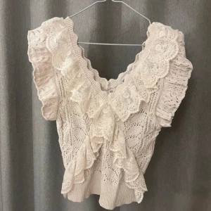 Beige volangtopp från Zara - Säljer en beige topp från Zara med volangdetaljer och v-ringning. Använd ett fåtal gånger och säljs inte längre på hemsidan.