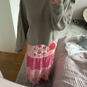 Rosa och vit långkjol - Säljer en färgglad långkjol i rosa och vitt med blommigt mönster. 