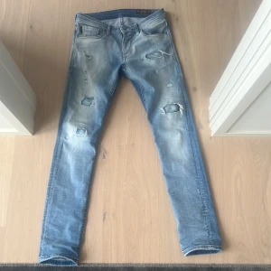 Jack and Jones Slim glenn - Feta ljusblå Jack and Jones Slim Glenn med slitningar storlek w30 l32. Målat vitt vid hålen för att få de se fetare ut. Bra skick, hör av dig vid funderingar 