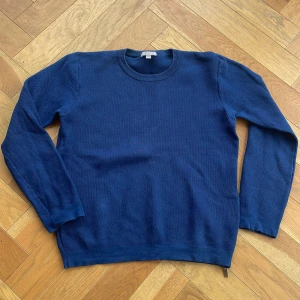 Blå stickad tröja från COS - Snygg blå stickad tröja från COS med dragkedja vid ena sidan