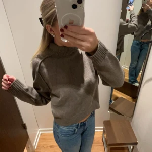 Brun stickad tröja - Säljer en mysig brun stickad tröja med långa ärmar och ribbade muddar. Perfekt för kyligare dagar. Tröjan har en klassisk design som passar till det mesta!