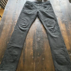 Svarta jeans från Dondup - Snygga svarta jeans från Dondup med en klassisk femficksdesign. De har en knappgylf och är tillverkade i ett stretchigt material för extra komfort. Perfekta för en stilren look.