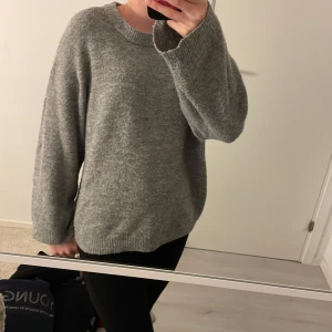 Grå stickad tröja från 157 - Mysig grå stickad tröja från 157 i storlek XS. Perfekt för kyliga dagar med sin bekväma passform och långa ärmar. Väldigt tun så bra för sommardagar också