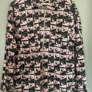 Svart och rosa jacka från Sweetsktbs - Cool jacka från Sweetsktbs med ett unikt svart och rosa mönster. Jackan har dragkedja och långa ärmar, perfekt för att sticka ut i mängden. Tillverkad i Indien.