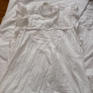 Vit sommar volang blus - Blus med spetsdetaljer och volanger vid ärmarna. Använd två gånger, köpte utomlands