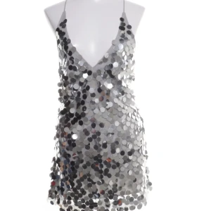 Silver paljettklänning öppen rygg - Snygg och glittrig silverfärgad klänning täckt med stora paljetter. Den har en djup v-ringning och öppen rygg. så snygg men passade inte mig riktigt😊