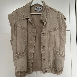 Beige jeansväst  - Cool jeans väst i beiget. Kan användas som både jacka och tröja om man stänger den. Köpt för 800kr från ett franskt märke. 