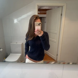 Mörkblå stickad tröja - Mörkblå stickad tröja med v-ringning och kabelstickat mönster. Köpt från hollister💕