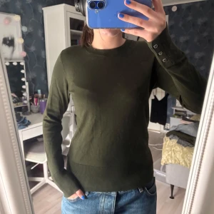 Olivgrön tröja från Holly & Whyte - Olivgrön långärmad tröja från Holly & Whyte by Lindex i storlek S. Den guldiga brickan har ramlat av