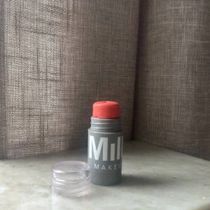 Milk Makeup stick rouge korall - Säljer ett stick rouge från Milk Makeup i en snygg korallrosa nyans. Kommer i en smidig grå plastförpackning med genomskinligt lock, perfekt att ha med i väskan. Krämig formula som är lätt att blenda ut på kinderna för en fräsch look.