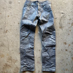 Waxed silvriga och glittriga jeans - Reworked jeans med glittrig och silvrig wax. Straight/skinny fit
