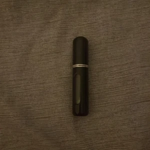 Svart refillbar parfymatomizer - Snygg och smidig svart parfymatomizer i plast med silverdetalj. Perfekt att ha med sig i väskan för att enkelt fräscha upp doften under dagen. Fönster på sidan så du ser hur mycket parfym som är kvar. Enkel att fylla på med din favoritparfym.