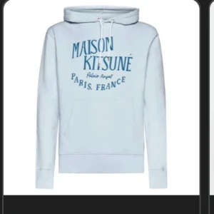 Maison Kitsuné ljusblå hoodie - Snygg ljusblå hoodie från Maison Kitsuné med tryck i blått framtill. Klassisk huva med snörning och stor magficka. Perfekt för dig som gillar streetstyle och vill ha något bekvämt men ändå trendigt.