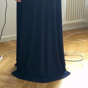 Mörkblå långklänning Chiara Forthi - Snygg mörkblå långklänning från Chiara Forthi med breda axelband och v-ringning. Klänningen har markerad midja och ett elegant, flytande fall. Perfekt för dig som vill ha en klassisk och stilren look.