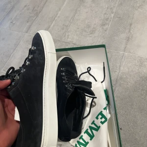 Svarta mockasneakers från Diemme - Snygga svarta sneakers från Diemme i mocka med vit platt sula. Skorna har metallhål för snörningen som ger en cool outdoor-vibe och klassisk rund tå. Perfekta för dig som gillar stilrena och exklusiva sneakers med italiensk känsla.