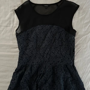 Svart och mörkblå topp från Lindex - Supersnygg spets och mesh topp från Lindex 💕 Den här vintage tröjan har varit älskad av min syrra men är i topp skick! Den övre mesh delen är svart medan blommönstrade spetsen är mörkblå med lite guldigt glitter ✨ 