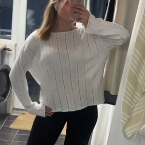 Vit stickad tröja med hålmönster - Säljer en vit stickad tröja med snygga vertikala hålmönster. Tröjan har en loose passform och långa ärmar, perfekt för dig som gillar en chill och stilren look. Passar lika bra till jeans som till kjol.
