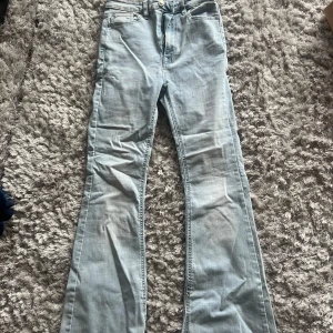 Ljusblå flare jeans - Säljer ett par ljusblå flare jeans med klassisk femficksdesign. Jeansen har en snygg och tidlös stil med en bekväm passform. Perfekta för en avslappnad look.