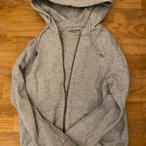 Jack & Jones zip  - Riktigt soft grå zip hoodie ifrån Jack & Jones. Den sitter väldigt bra och ser väldigt bra ut, skön och varm!