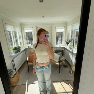 Vit ribbad topp med svarta kanter - Säljer en söt vit ribbad topp med svarta kanter. Toppen är kortärmad och har en croppad passform med vågig kant nedtill. Perfekt för en avslappnad stil.