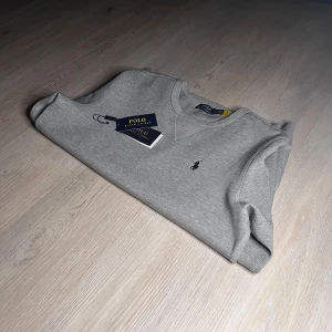 Grå tröja från Polo Ralph Lauren - Säljer em oanvänd och stilren tröja från Polo Ralph Lauren färgad grå. Tröjan är i storlek S och är köpt för cirka 1800kr