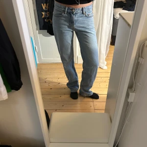Ljusblå jeans - Säljer ett par klassiska ljusblå jeans med normal passform och medel midja. De har en rak stil och är perfekta för en avslappnad look. Jeansen har fem fickor och stängs med dragkedja och knapp.