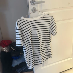 Vit och svart randig t-shirt - Säljer en klassisk vit och svart randig t-shirt med korta ärmar. Perfekt för en avslappnad stil. Passar bra till jeans eller shorts.