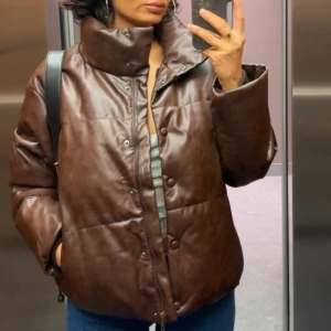 Brun pufferjacka i skinn - Snygg brun pufferjacka i skinn med hög krage och knappar. Perfekt för kyliga dagar med sin quiltade design och långa ärmar. En stilren jacka som ger en cool look.