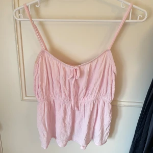 Rosa linnetopp - Söt rosa linnetopp med justerbara axelband och knytning framtill. Lätt och luftigt material, perfekt för en varm sommardag. Linnet är i storlek XS/34 och är endast testad på! Tyvärr en storlek fel för mig så därför säljs den